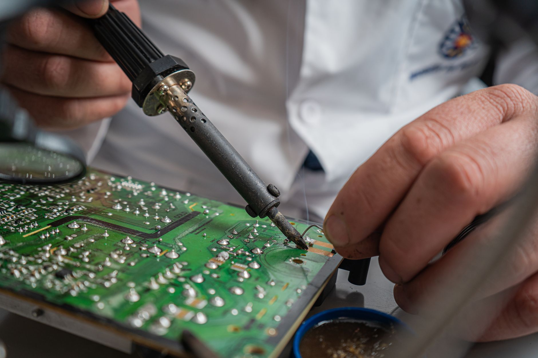 A soldering iron tinning a joint on a console board